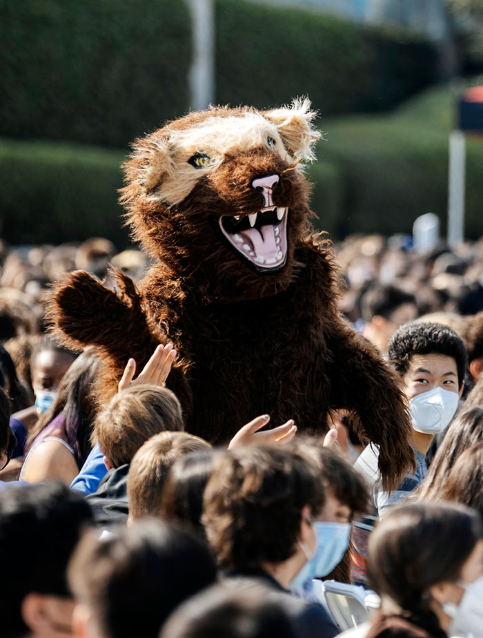 Wolverine mascot giving a high five.